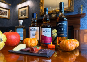 Whisky bottles with pumpkins and food items