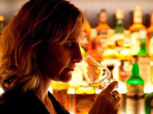 Lady nosing a whisky glass within one of the World's Largest Collections of Scotch Whiskies.