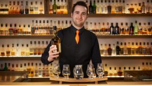 barman with whisky stave and bottle