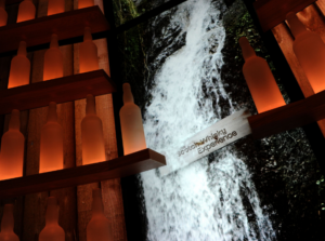 Waterfall on a screen with bottles illuminated within the Scotch Whisky Experience Shop