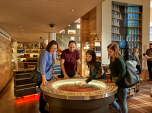 A staff member showing customers the aroma flavour wheel within the Scotch Whisky Experience Shop
