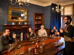 The Stillhouse Suite at The Scotch Whisky Experience with the table set with whisky tasting staves and customers enjoying a tasting.