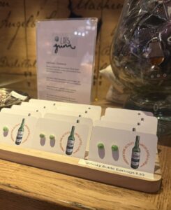 Handmade green stud earrings on shop display counter.