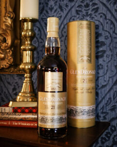 Bottle of Glendronach 21yo, pictured with books and a gold candleholder.