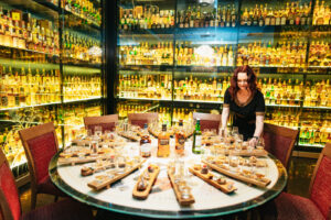Whisky tasting table set up with whisky, staves and canapes, with tour guide.