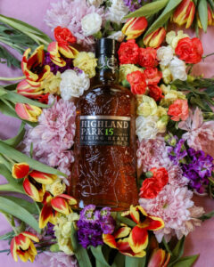 Bottle of Highland Park 15yo for March Whiskies of the Month with flowers in the background.