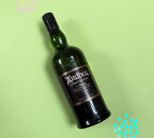 Bottle of Scotch whisky against green background with glitter gems.