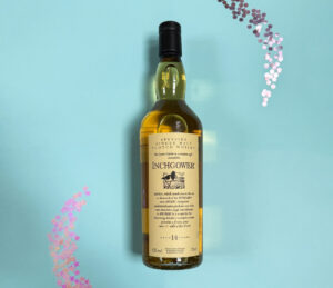 Bottle of Scotch whisky against blue background with glitter gems.