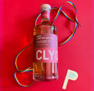 Bottle of Clydeside whisky against a red background with rainbow laces and the letter P.