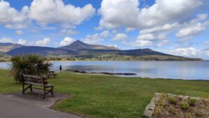 Landscape photo of the Isle of Arran featuring a hill and water.