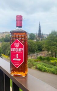 Bottle of Antiquary 15 whisky facing with George IV statue in the background.