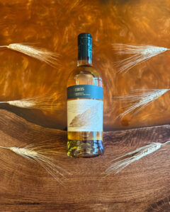 Bottle of Maclean's Nose Scotch Whisky on an Amber coloured table with barley.