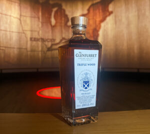 Bottle of Glenturret Triple Wood Scotch whisky against a projection of a map showcasing Kentucky with a wood effect.
