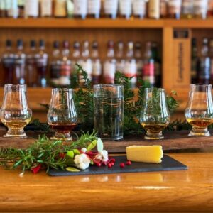 A flight of four whiskies with cheese and a festive decoration
