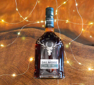 Bottle of Dalmore 15yo Scotch whisky on an amber table with fairy lights.